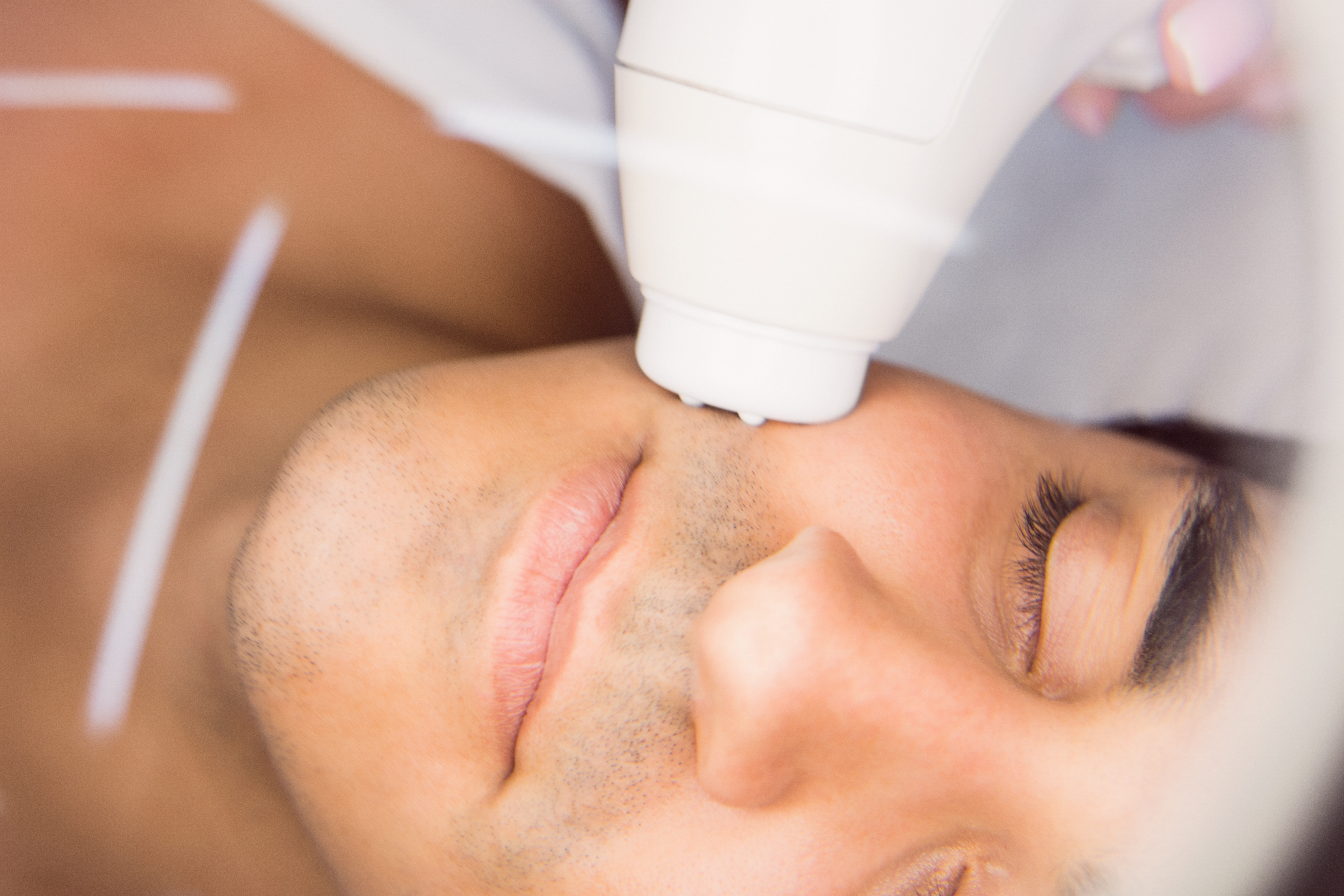 Man getting a facial massage for cosmetic treatment at clinic